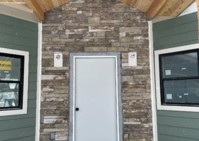 Entrance way to new home stone wall and wooden slats on ceiling
